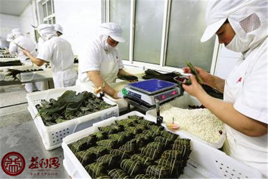 益康員工們正在精心制作送往濟南艦的粽子