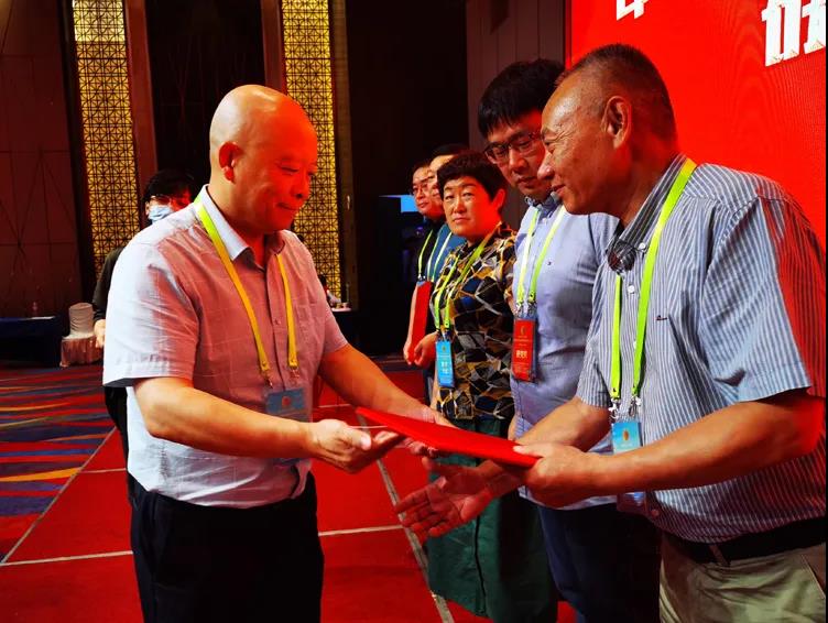 中華文化促進會糕餅文化委員會會長王長龍為獲獎企業(yè)代表頒獎