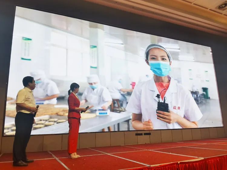 主持人現(xiàn)場連線守候在益康食品廠生產(chǎn)一線的外景記者