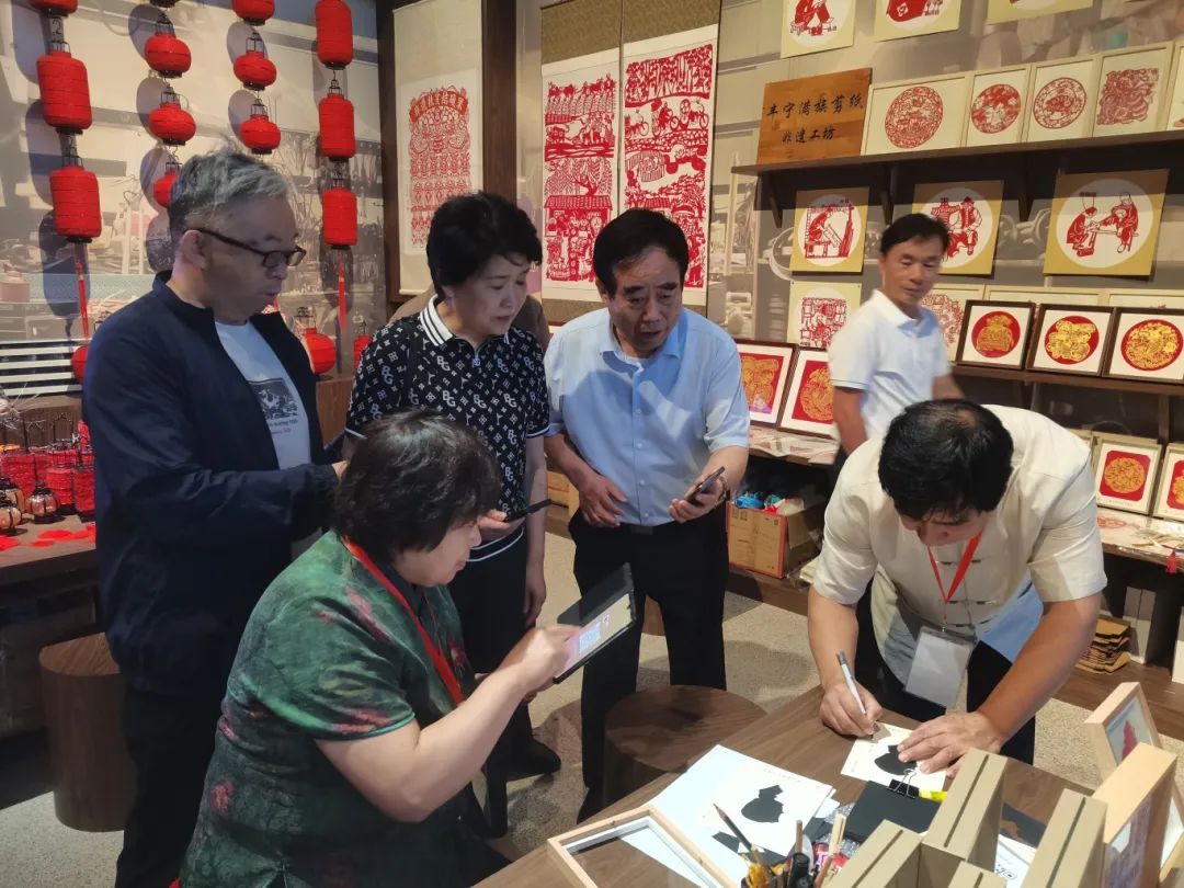 ▲參觀并體驗非遺剪紙技藝